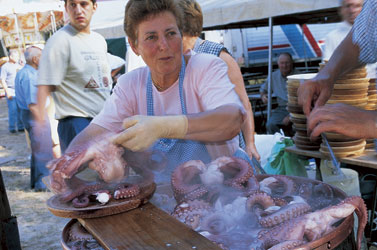 woman smiling putting squid into a vat